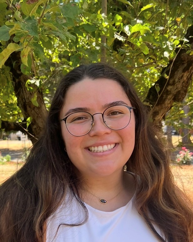 kelsey racacho second year t32 trainee in front of foiliage