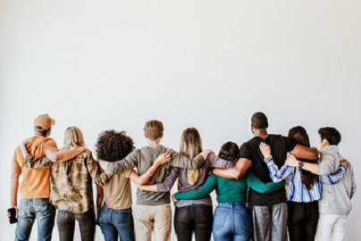 diverse group of people standing with their arms around each other