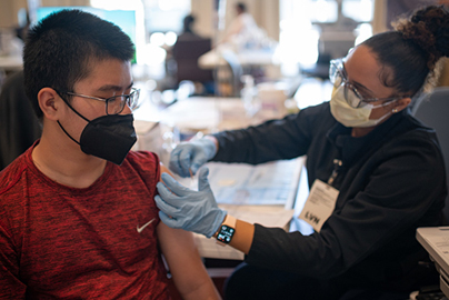 Young girl receiving a vaccination from a health care worker.