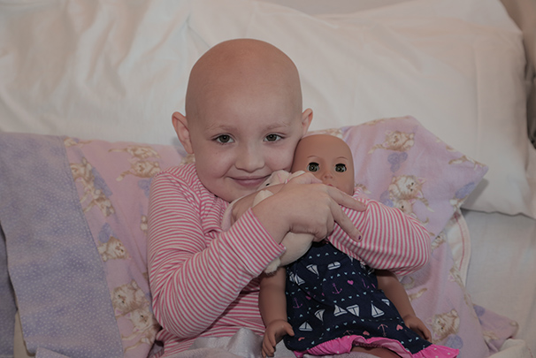 A child holding an American Girl Doll that looks like her.