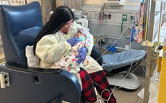 Mother holding her newborn in the NICU