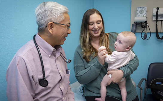 Frank Ing, chief of pediatric cardiology, with a mother and her baby