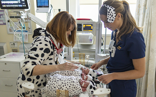 Nurses with babies dressed up like Dalmatians