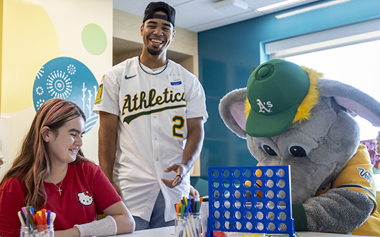 Pediatric patient with Athletic A’s player and mascot