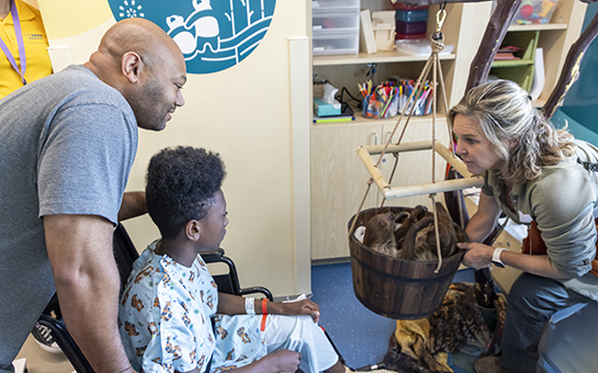 Wildlife expert showing a father and son otters during a children’s hospital event