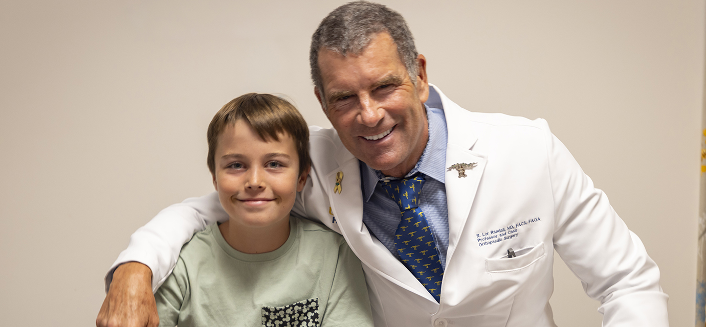 R. Lor Randall, chair of the Department of Orthopaedic Surgery, with pediatric orthopaedic patient Ryder