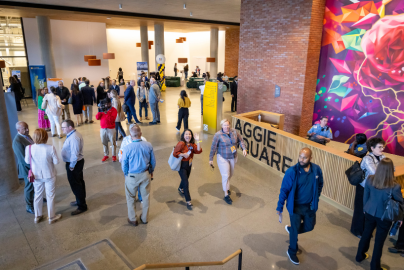 Aggie Square's lobby is shown from above as a crowd circulates around a modern, bright interior. 