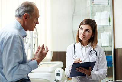 Patient talking to doctor holding a clipboard