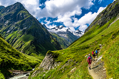 Hikers walking through a sunny mountain scape