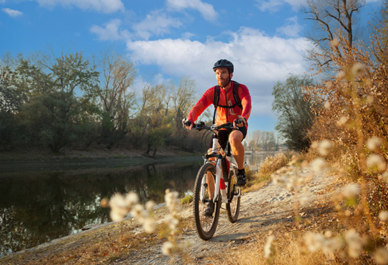 Man riding a bike on trails outdoors to stay active.