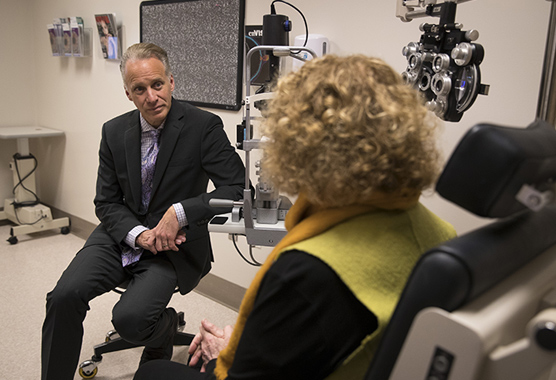 Ophthalmologist discussing corneal disorders with patient in clinic.