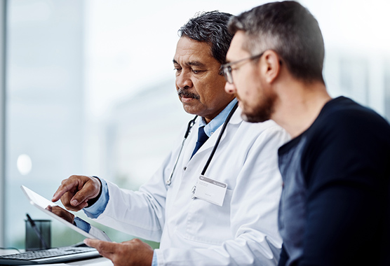 Urologist talking to male patient with erectile dysfunction.
