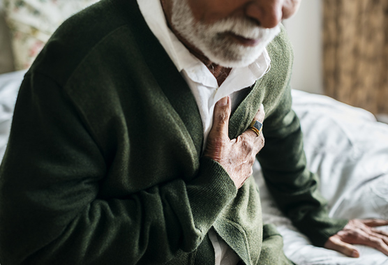 Man grasping at his chest during a heart attack.