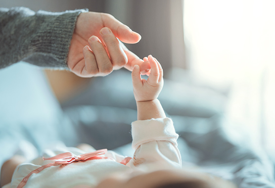 Infant with hydronephrosis holding the finger of an adult.