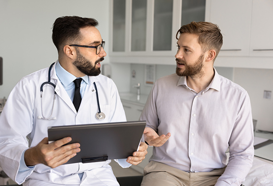 Man with Klinefelter Syndrome talking to health care provider in clinic.