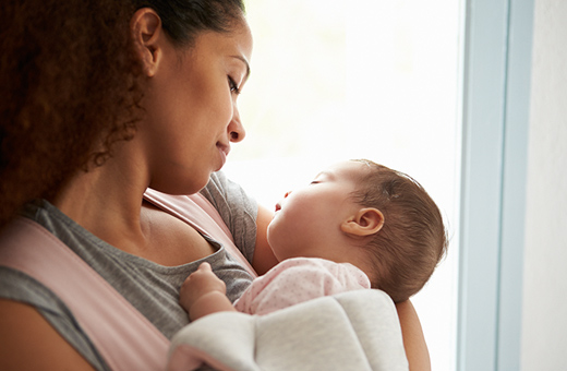 Mom looking down at newborn baby after breastfeeding.