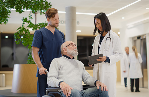 Man in a wheelchair with two health care providers going to get imaging before esophagectomy.