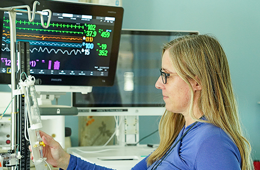 Health care professionals monitoring patient in trauma recovery.