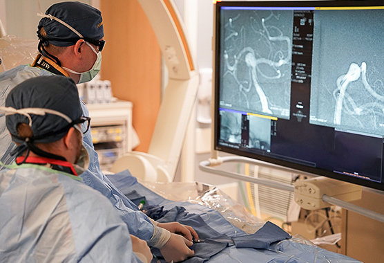 Neurosurgeons performing vascular neurosurgery on patient.