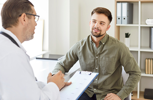 A male doctor and patient discuss vasectomy.