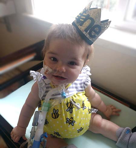 Everly wearing hat that says “One.”