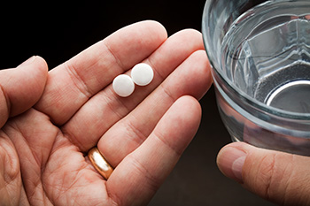 Hand holding pills and water
