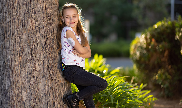 Young person leaning against a tree