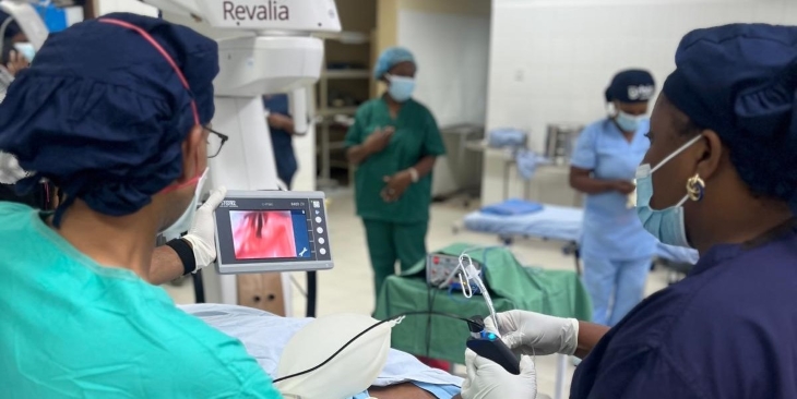 Two physicians in an operating room look at a screen showing the patient’s airway. 