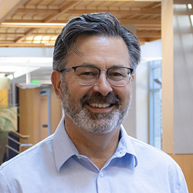 A man stands in a medical facility smiling for a photo