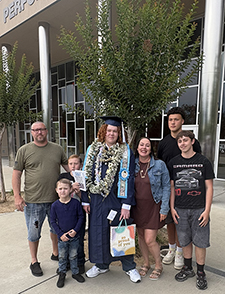 4 boys, 2 men and one woman pose together for a graduation photo,