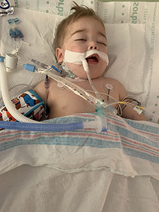 Baby in a hospital bed with tubes that lead to lifesaving equipment.