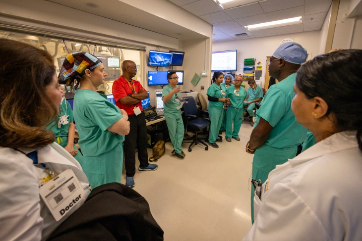 A multidisciplinary care team gathers in the electrophysiology lab for a group briefing.