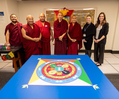 Monks from the Gaden Shartse Monastery pose in a group photo with Katie Lorain and other IFIC board members