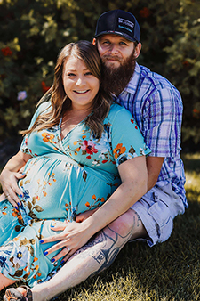 Man and pregnant woman cradling her belly.