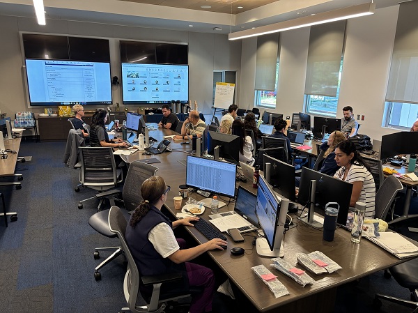 Room with staff working at computers and monitors in a Command Center setting supporting supply coordination at UC Davis Health