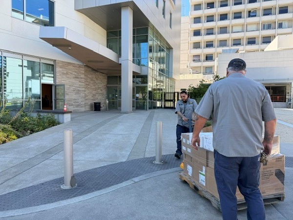 Delivery of boxed medical supplies on a pallet as team members prepare to move items into the building for distribution
