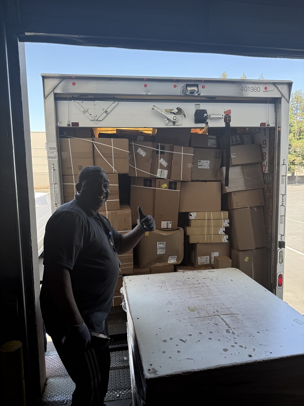 Team member unloading boxes of medical supplies from a delivery truck at UC Davis Health loading area