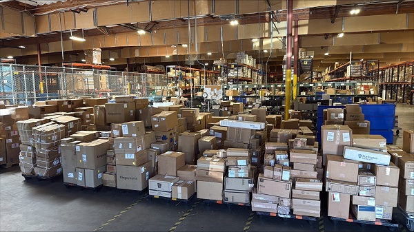 Pallets of boxed medical supplies arranged in rows inside a UC Davis Health warehouse ready for processing and delivery