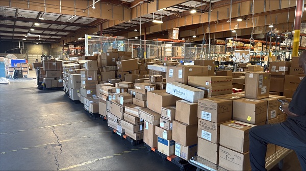Large warehouse space with pallets of boxes and medical supplies organized for distribution at UC Davis Health
