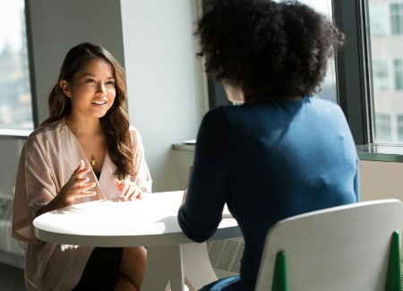 Two women talking while sitting across from each other