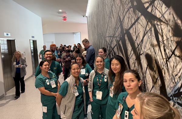 UC Davis Health employees line a hallway while waiting to attend a Puppy Playtime event.