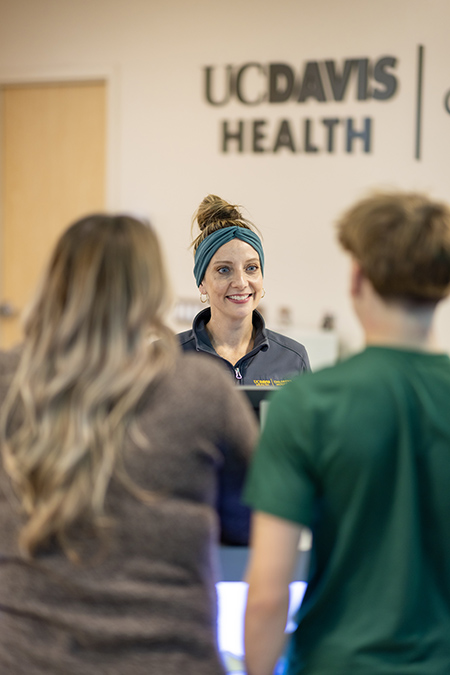 Receptionist greets a mother and child patient