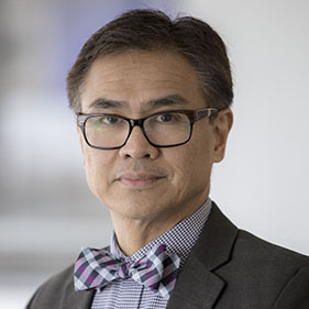 A man with dark hair, wearing a gray suit with a bowtie, Dr. Primo "Lucky" Lara Jr.