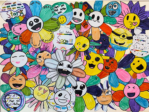 Colorful collage of smiling flower characters created by elementary school students, featuring handwritten messages of encouragement.