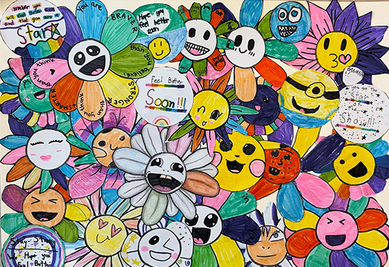 Colorful collage of smiling flower characters created by elementary school students, featuring handwritten messages of encouragement.