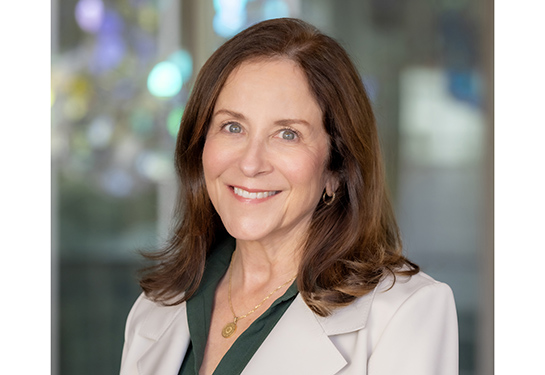 Susan Murin smiling in a green top and white blazer