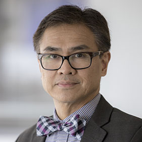  Physician Primo “Lucky” Lara Jr., wearing a suit jacket and botwie.