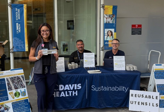 Staff sit at a Sustainability information booth.