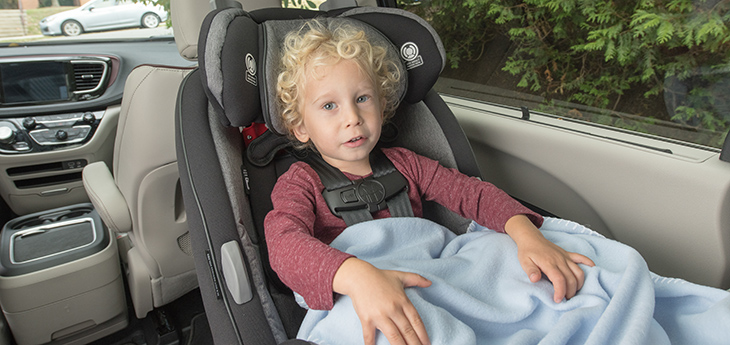 Child using car seat with blanket.