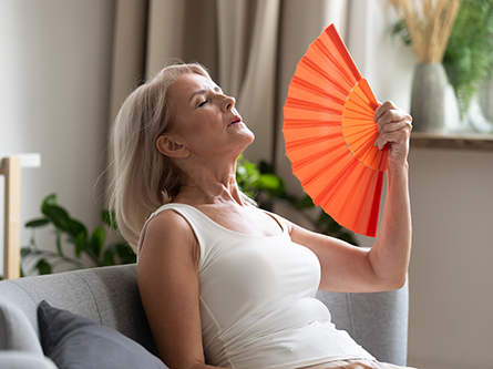 women leaning back fanning herself.